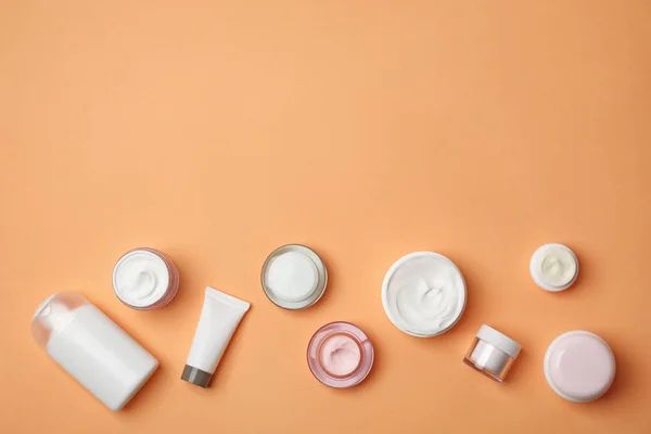 Composição de leigos planos com produtos cosméticos no fundo de cor — Fotografia de Stock