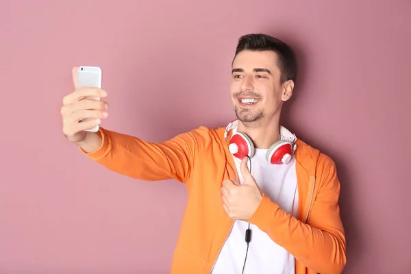 Beau homme prenant selfie sur fond de couleur — Photo