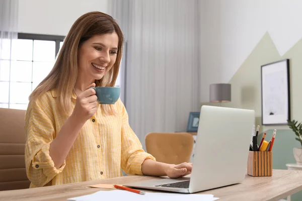 Jonge vrouw met laptop werken aan balie in kantoor aan huis — Stockfoto