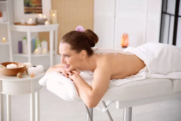Mulher bonita fazendo massagem com esfoliação corporal no salão de spa — Fotografia de Stock