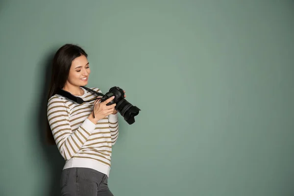 年轻女摄影师与照相机在灰色背景 — 图库照片