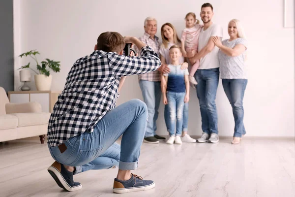 Fotógrafo profissional tirando foto de família em estúdio — Fotografia de Stock
