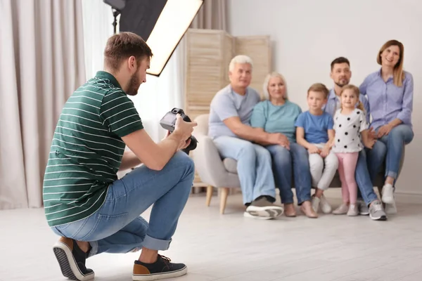 Профессиональный фотограф фотографирует семью на диване в студии — стоковое фото