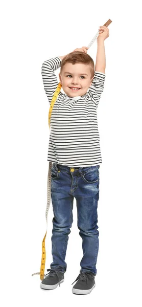 Liten pojke mätning av hans höjd på vit bakgrund — Stockfoto