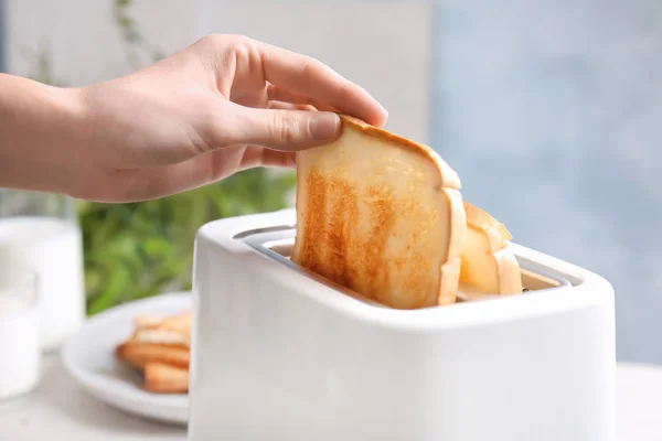 Mujer tomando rebanada de pan de tostadora, primer plano —  Fotos de Stock