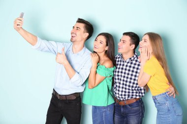 Selfie renk arka plan karşı alarak genç mutlu arkadaşlar