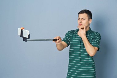 Yakışıklı delikanlı selfie gri bir arka plana dayanır alarak
