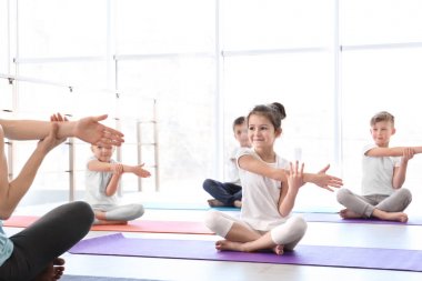 Küçük çocuklar ve pratik spor salonunda yoga öğretmeni
