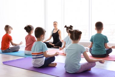 Küçük çocuklar ve pratik spor salonunda yoga öğretmeni