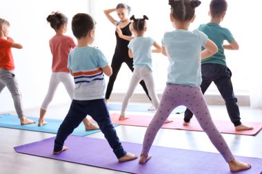 Küçük çocuklar ve pratik spor salonunda yoga öğretmeni