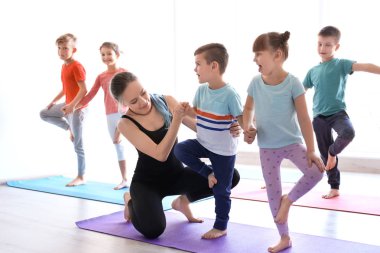 Küçük çocuklar ve pratik spor salonunda yoga öğretmeni