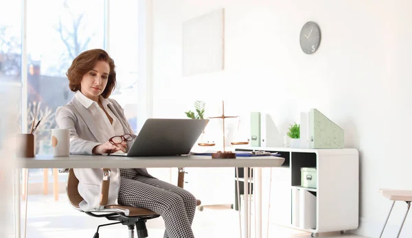 사무실에 테이블에서 노트북으로 일 하는 여성 변호사 — 스톡 사진