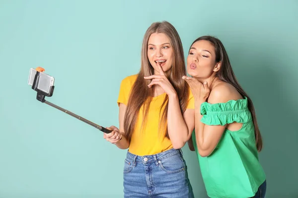 Jóvenes mujeres hermosas tomando selfie contra el fondo de color — Foto de Stock