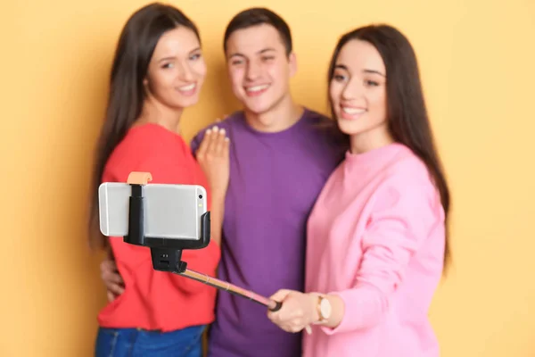 Junge glückliche Freunde machen Selfie vor farbigem Hintergrund — Stockfoto