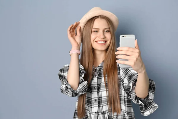 Jovem bela mulher tomando selfie contra fundo cinza — Fotografia de Stock