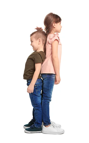 Niños pequeños midiendo y comparando su altura sobre fondo blanco — Foto de Stock