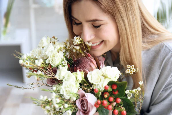 Vrouwelijke bloemist met prachtige boeket op werkplek — Stockfoto