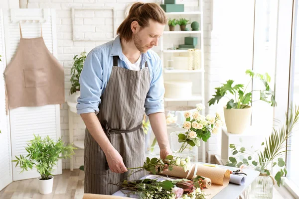 Floristería masculina creando ramo en el lugar de trabajo — Foto de Stock