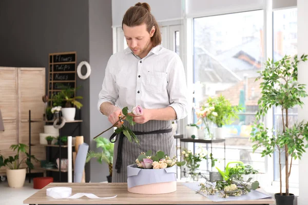 Floristería masculina creando composición floral en el lugar de trabajo — Foto de Stock