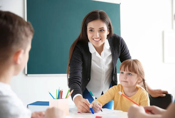 Lehrerin hilft Mädchen bei ihrer Aufgabe in der Schule — Stockfoto