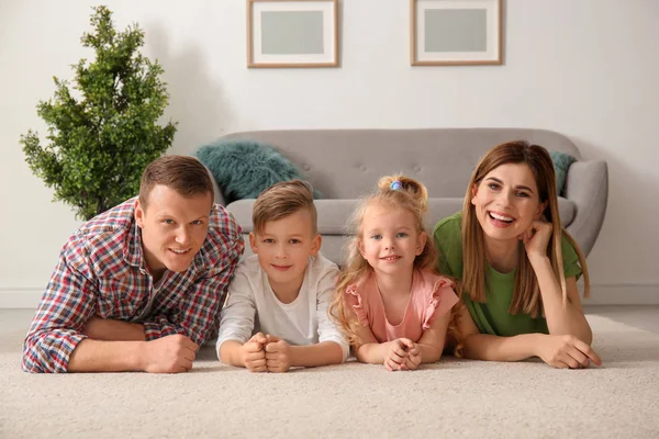 Lycklig familj liggande på mysiga mattan hemma — Stockfoto