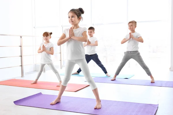 Malé děti cvičí jógu v tělocvičně — Stock fotografie