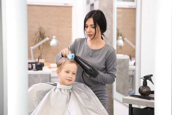 プロの女性美容師がサロンで男の子と作業 — ストック写真