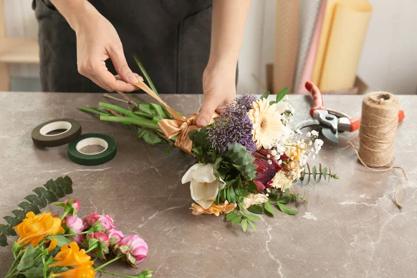 Florista feminina fazendo belo buquê à mesa — Fotografia de Stock