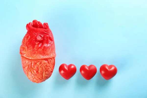 Model ve renk arka plan üzerinde küçük kırmızı kalpler. Kalp krizi kavramı — Stok fotoğraf