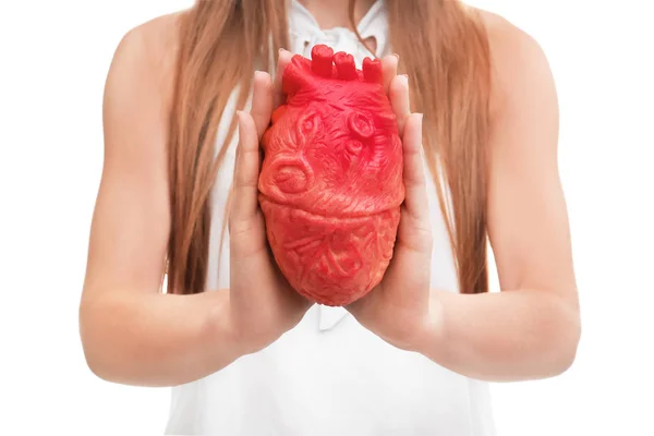 Mujer sosteniendo modelo de corazón sobre fondo blanco. Concepto de ataque cardíaco — Foto de Stock