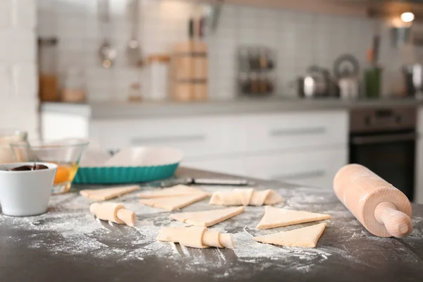 Samenstelling met ingrediënten en ruwe croissants op tafel in de keuken — Stockfoto