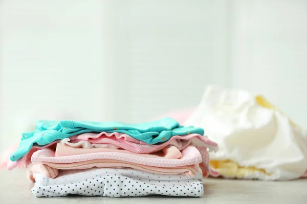 Montón de ropa de bebé en la mesa — Foto de Stock
