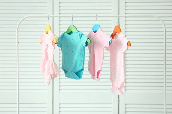 Vêtements de bébé suspendus sur le rack, à l'intérieur — Photo