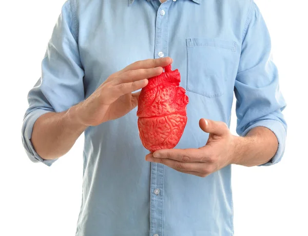 Hombre sosteniendo modelo de corazón sobre fondo blanco. Concepto de ataque cardíaco — Foto de Stock