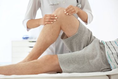 Doktor muayene erkek hasta yaralı bacak, closeup ile