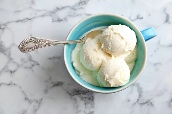 Copo com saboroso sorvete de baunilha no fundo claro — Fotografia de Stock