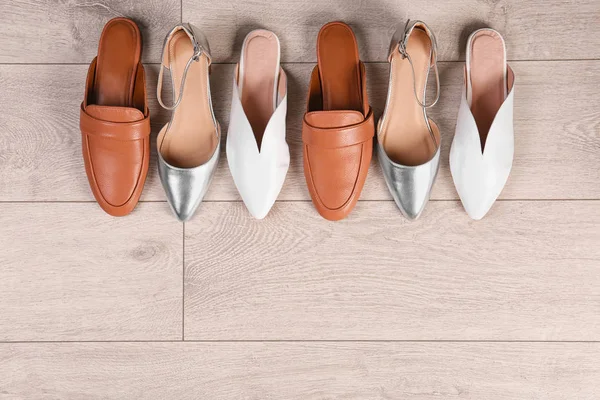 Zapatos femeninos diferentes sobre fondo de madera, vista superior — Foto de Stock