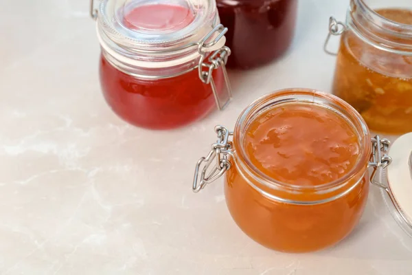 Gläser mit verschiedenen süßen Marmeladen auf dem Tisch — Stockfoto