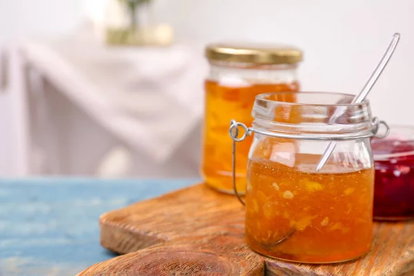 Gläser mit leckerer süßer Marmelade auf Holztisch — Stockfoto