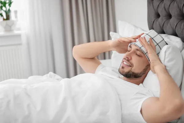 Homme souffrant de maux de tête alors qu'il était allongé sur son lit à la maison — Photo