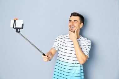 Yakışıklı delikanlı selfie gri bir arka plana dayanır alarak