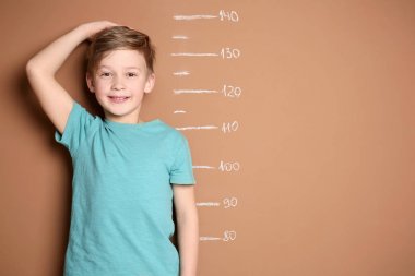 Küçük çocuk renk arka plan üzerinde onun yükseklik ölçme