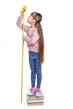 Little girl measuring her height on white background clipart