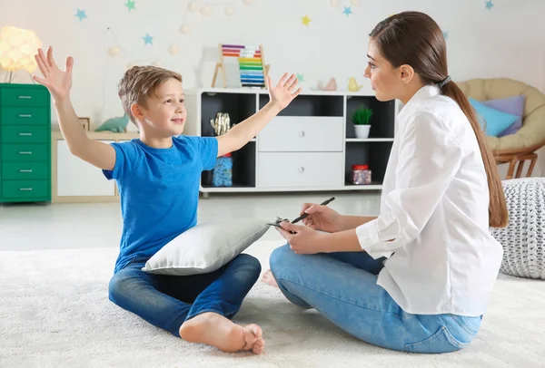 Vrouwelijke psycholoog werken met schattige kleine jongen in kantoor — Stockfoto