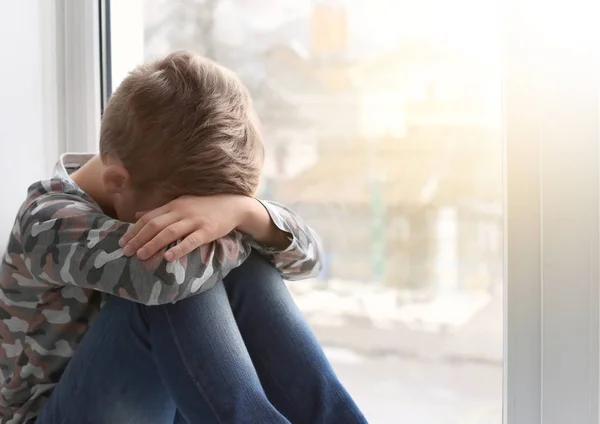 Μοναχικό μικρό αγόρι κοντά σε παράθυρο σε εσωτερικούς χώρους. Το παιδί αυτισμό — Φωτογραφία Αρχείου