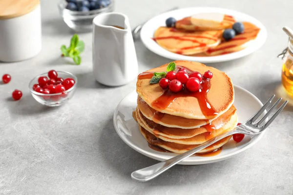 Setumpuk pancake lezat dengan buah beri dan sirup di atas meja — Stok Foto