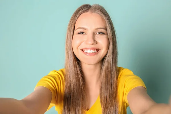 Νεαρή όμορφη γυναίκα που παίρνει selfie με φόντο το χρώμα — Φωτογραφία Αρχείου