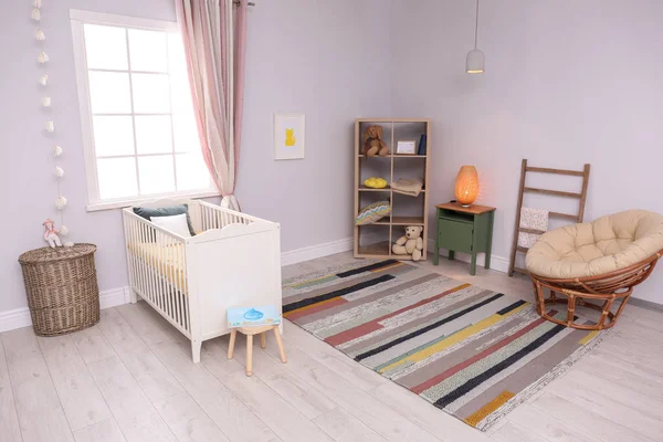 Interior de la habitación del bebé con cuna cómoda y silla de papasán — Foto de Stock