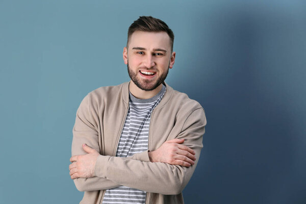 Portrait of confident young man on color background