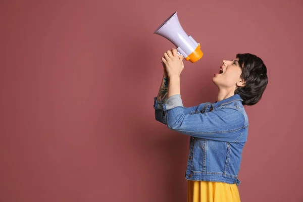 Mladá žena křičí do megafon na barvu pozadí — Stock fotografie